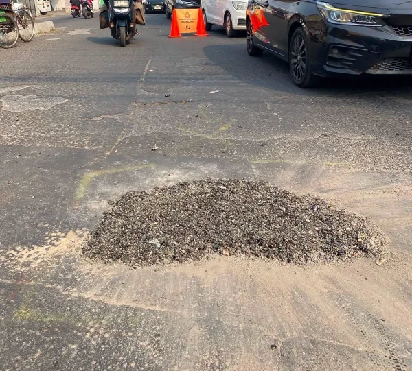 material aspal dituangkan pada area jalan yang rusak